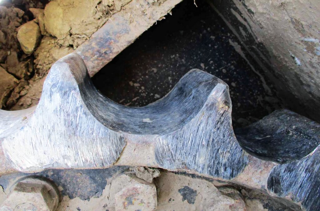 Zbliżenie na zużyty tryb napędu w podwoziu maszyn budowlanych.